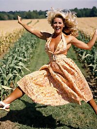 A sultry blonde clad in a 1950s halter dress walks through the cornfield at noon
